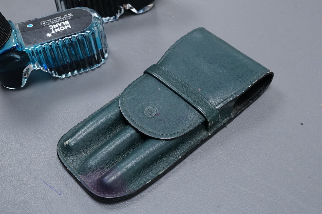 Three Mont Blanc pens in a green leather Mount Blanc case and two inkwells.